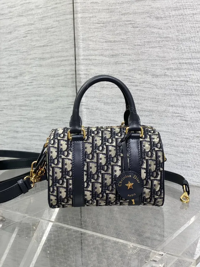 View 1 of Structured Luxe Navy Leather Mini Duffle Bag with Monogram Charm