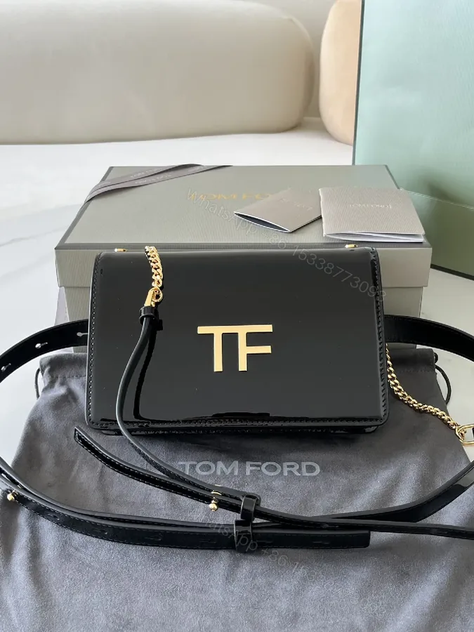 View 1 of Compact Black Leather Crossbody with Gold TF Emblem