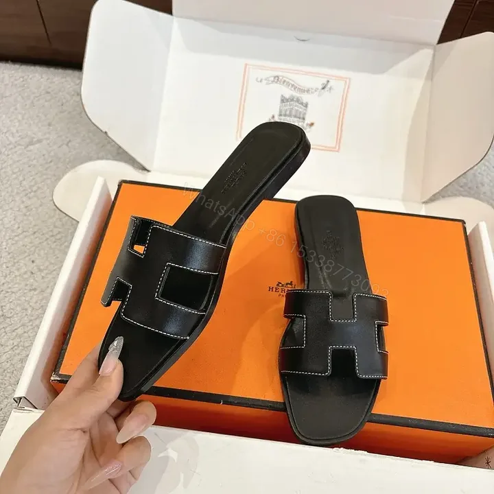 View 1 of black leather slide sandals with H-shaped buckles for luxury everyday