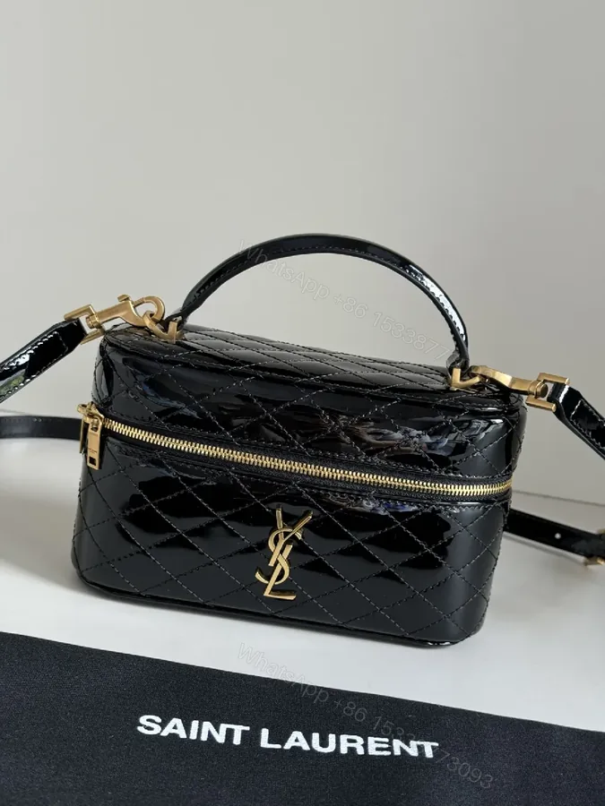 View 1 of Compact Black Quilted Handbag with Gold Accent Emblem