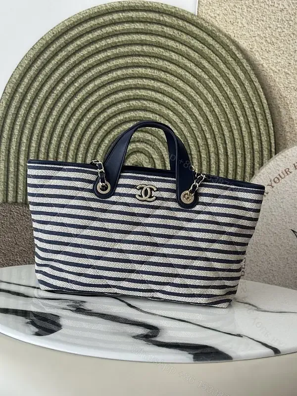 View 1 of Navy Stripe Woven Tote Bag with Leather Accents and Chanel Logo
