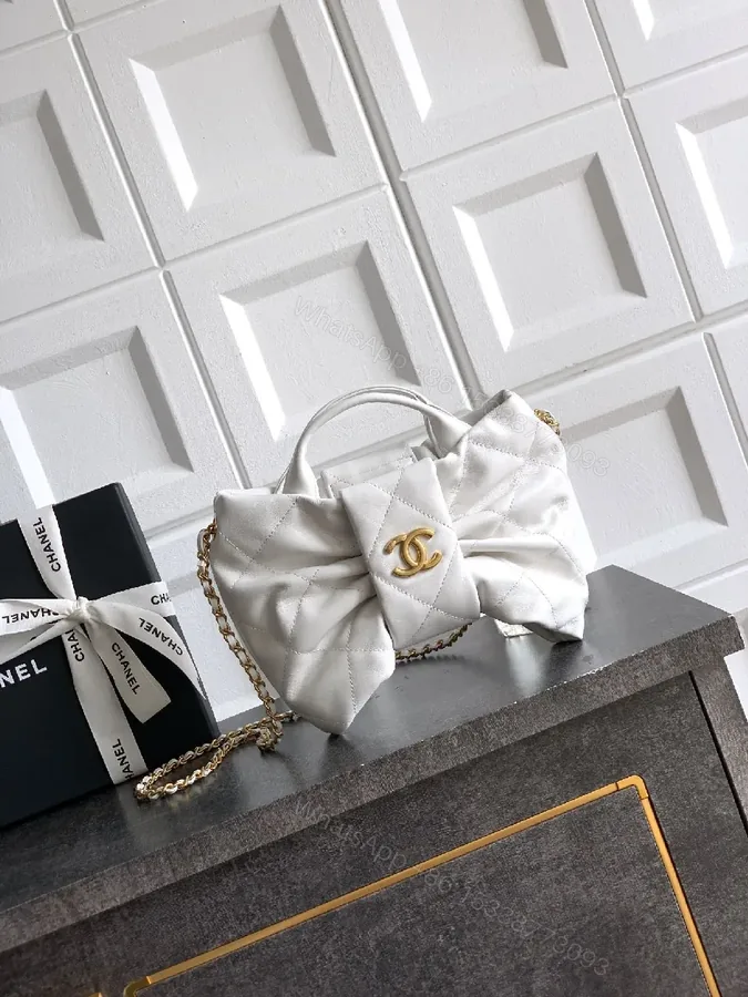 View 1 of Pearl White Quilted Satin Mini Bag with Bow Detail and Gold Logo