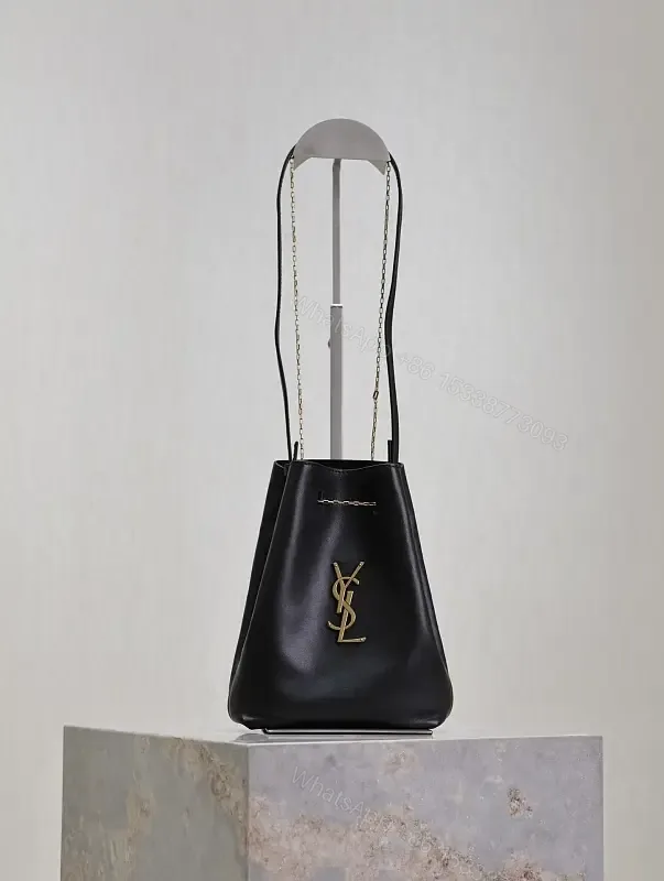 View 1 of Black leather bucket bag with gold-tone YSL monogram and chain straps for everyday luxury