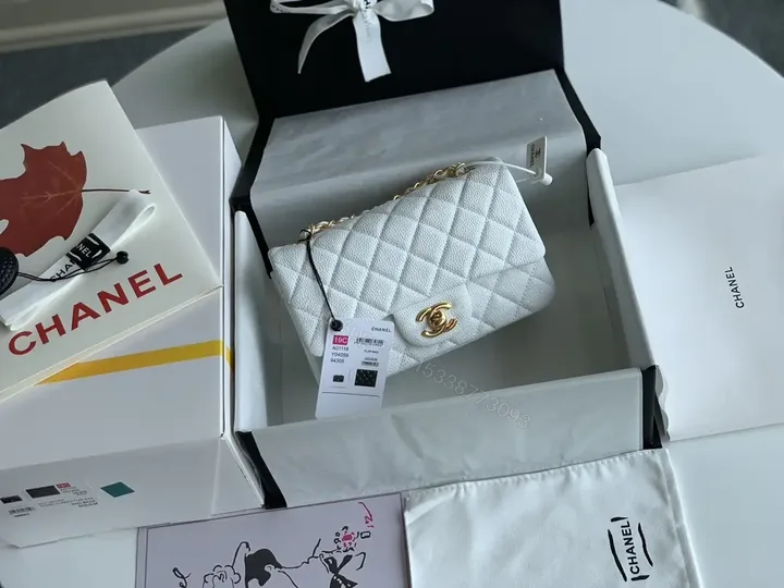 View 1 of Quilted White Flap Bag with Gold Hardware—Compact Elegance
