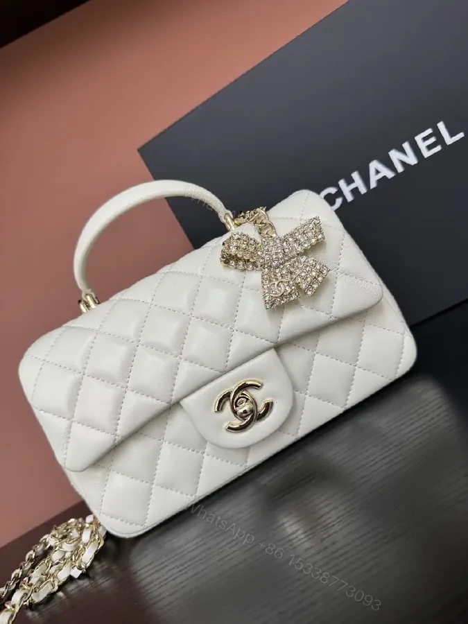 View 1 of White Quilted Luxe Handbag with Diamond Bow Charm - Satchel Style