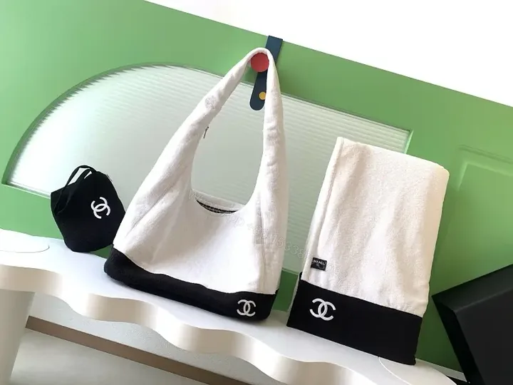 View 1 of White Fabric Handbag with Black Trim Slouchy Style Chanel Logo Tote