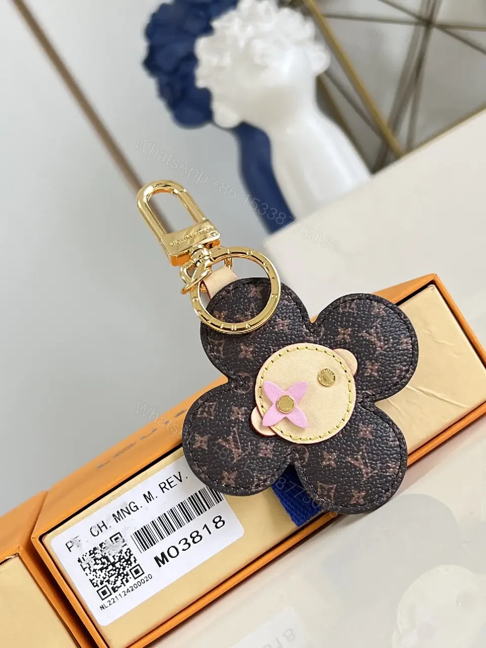 View 10 of White Leather-like Quilted Flower Keychain - LV Monogram Accent, Gold Hardware