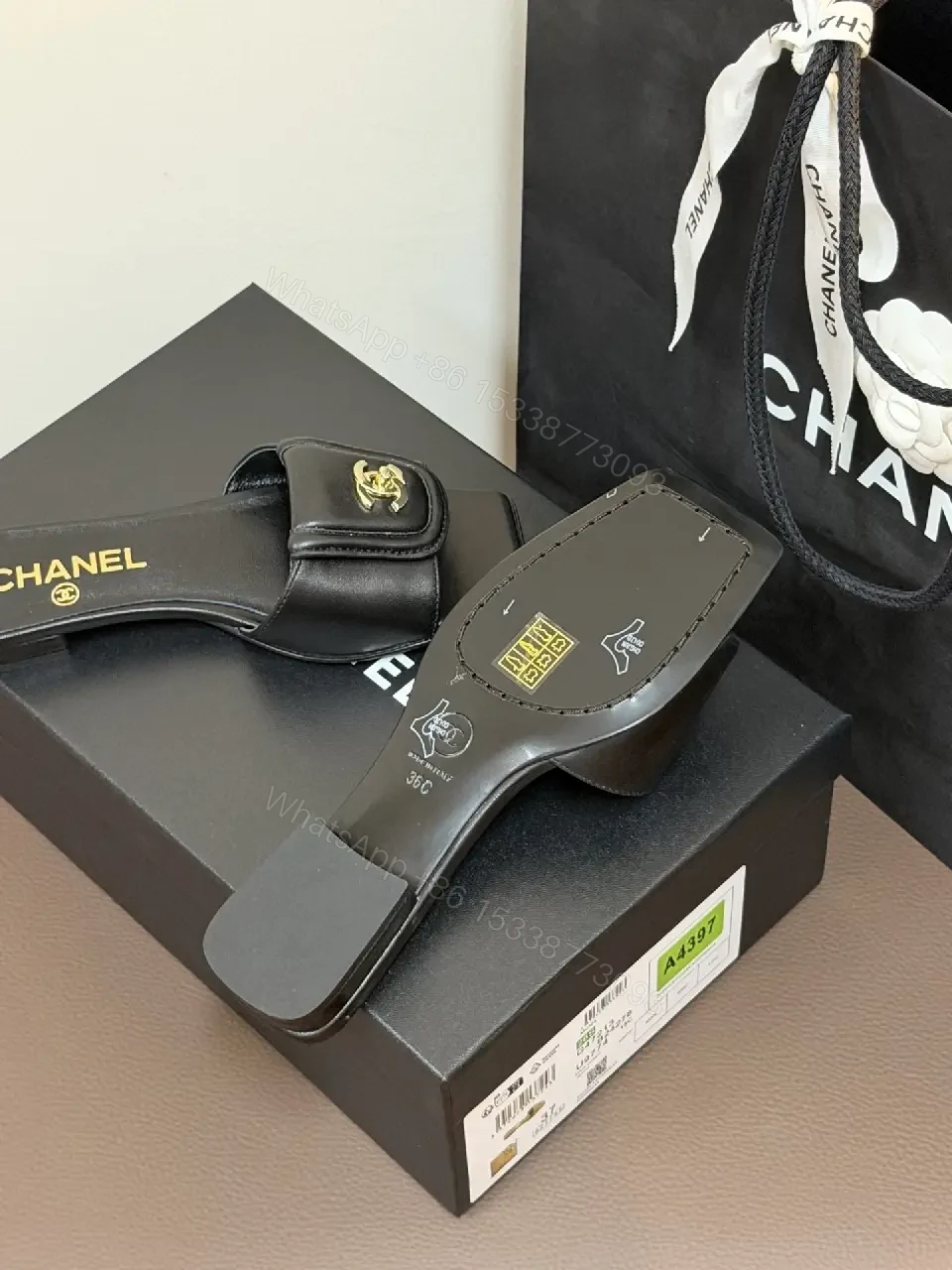 View 2 of Black Leather Mules with Gold Logo Detail – Effortless Chic