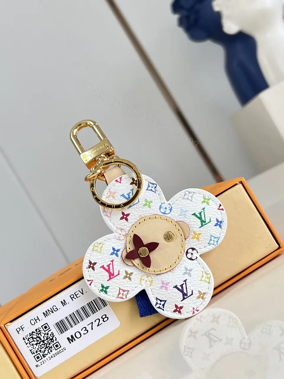 View 2 of White Leather-like Quilted Flower Keychain - LV Monogram Accent, Gold Hardware