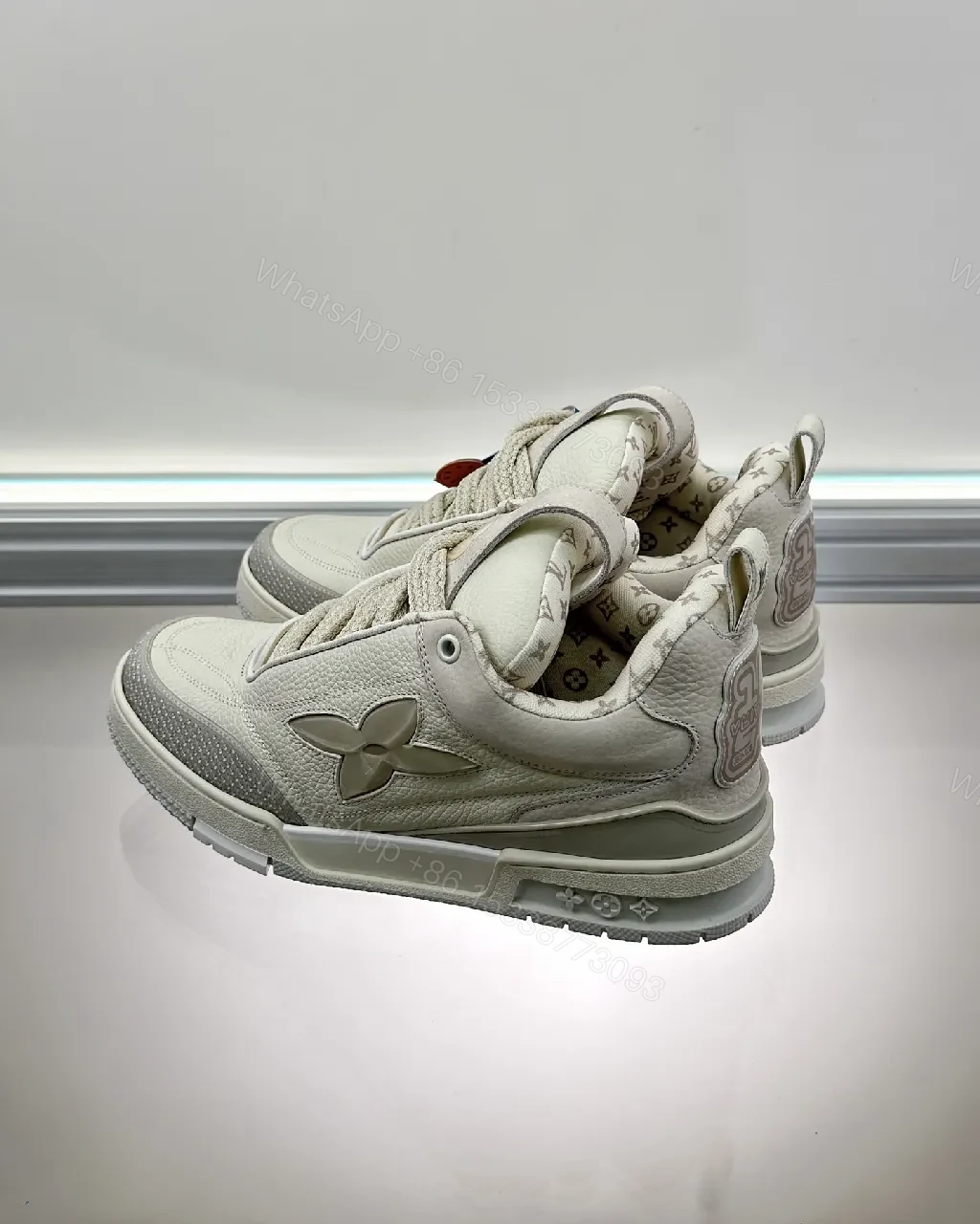 View 3 of Textured White Leather Sneakers with Signature Motif, Modern Luxury