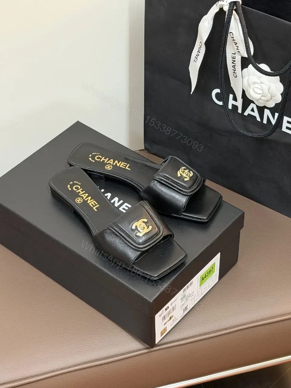 View 6 of Black Leather Mules with Gold Logo Detail – Effortless Chic
