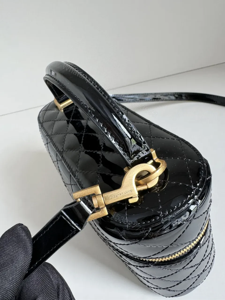 View 4 of Compact Black Quilted Handbag with Gold Accent Emblem