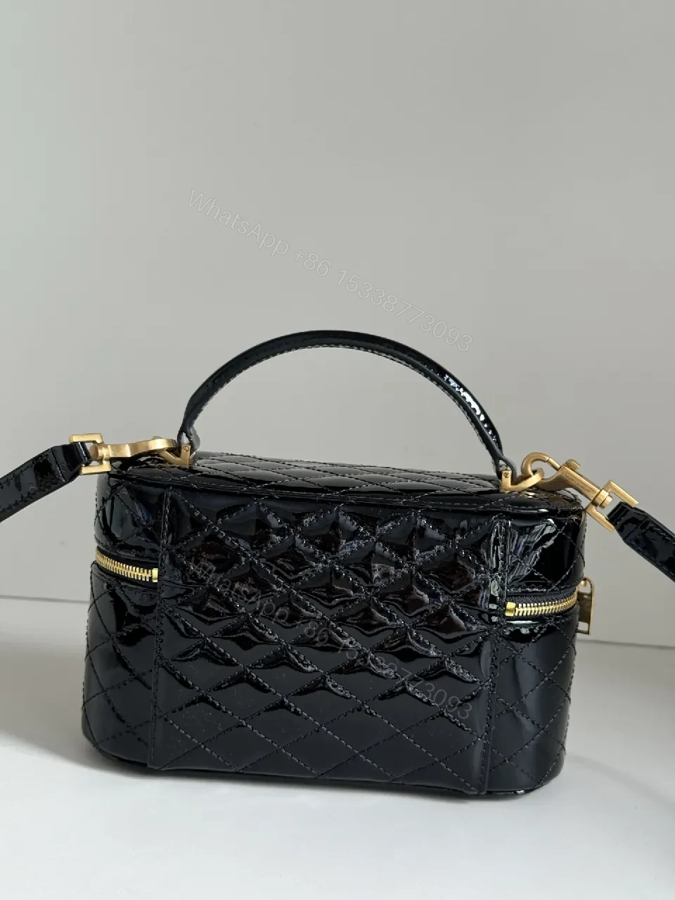 View 5 of Compact Black Quilted Handbag with Gold Accent Emblem