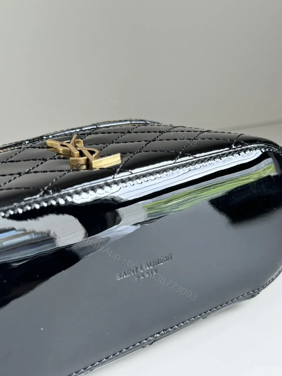View 2 of Compact Black Quilted Handbag with Gold Accent Emblem