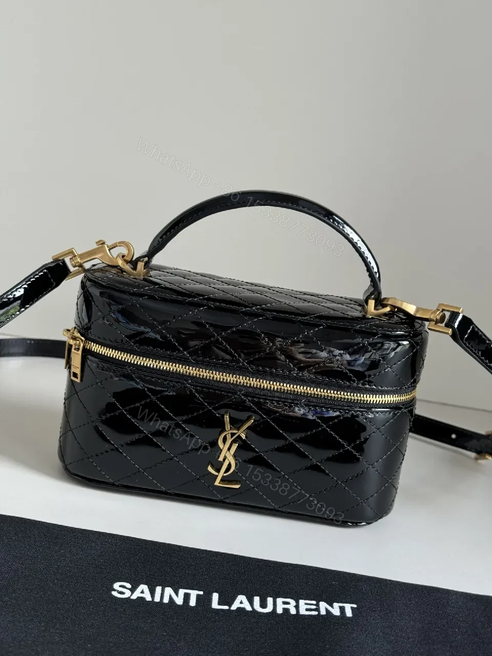 Compact Black Quilted Handbag with Gold Accent Emblem — view 1