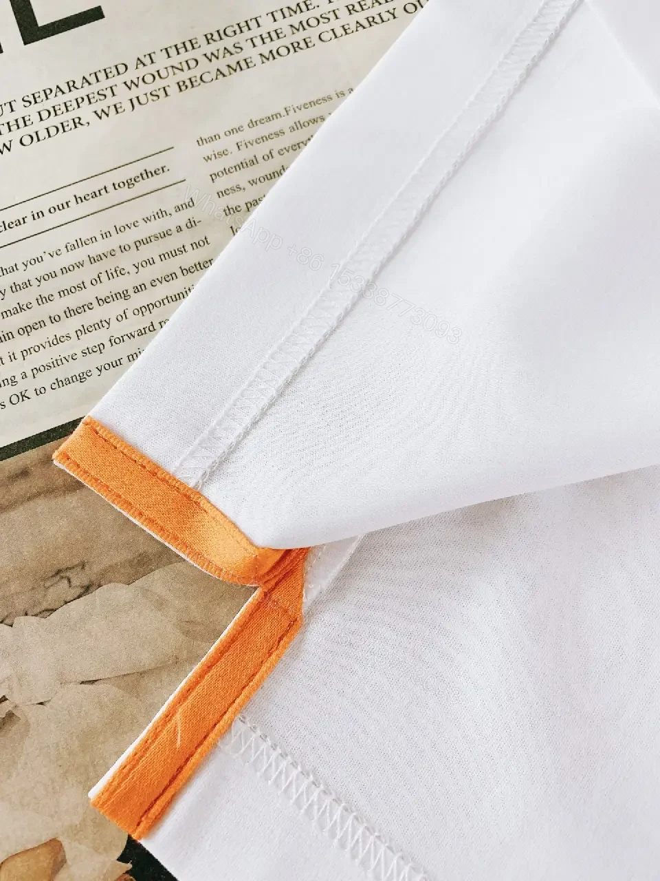 View 4 of Minimalist White Tee with Bold Orange Emblem T-Shirt