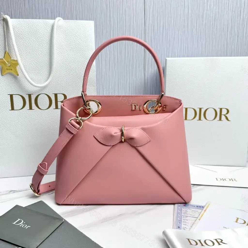 View 2 of Soft Pink Faux-Leather Satchel: Bow Accent, Sculpted Diagonal Panels, Crossbody Comfort