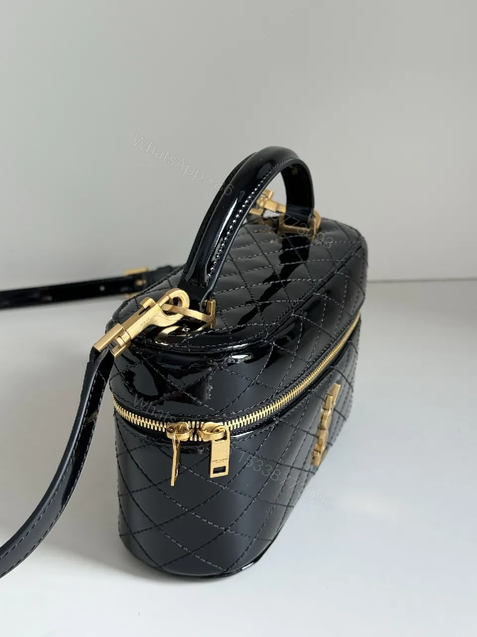 View 7 of Compact Black Quilted Handbag with Gold Accent Emblem