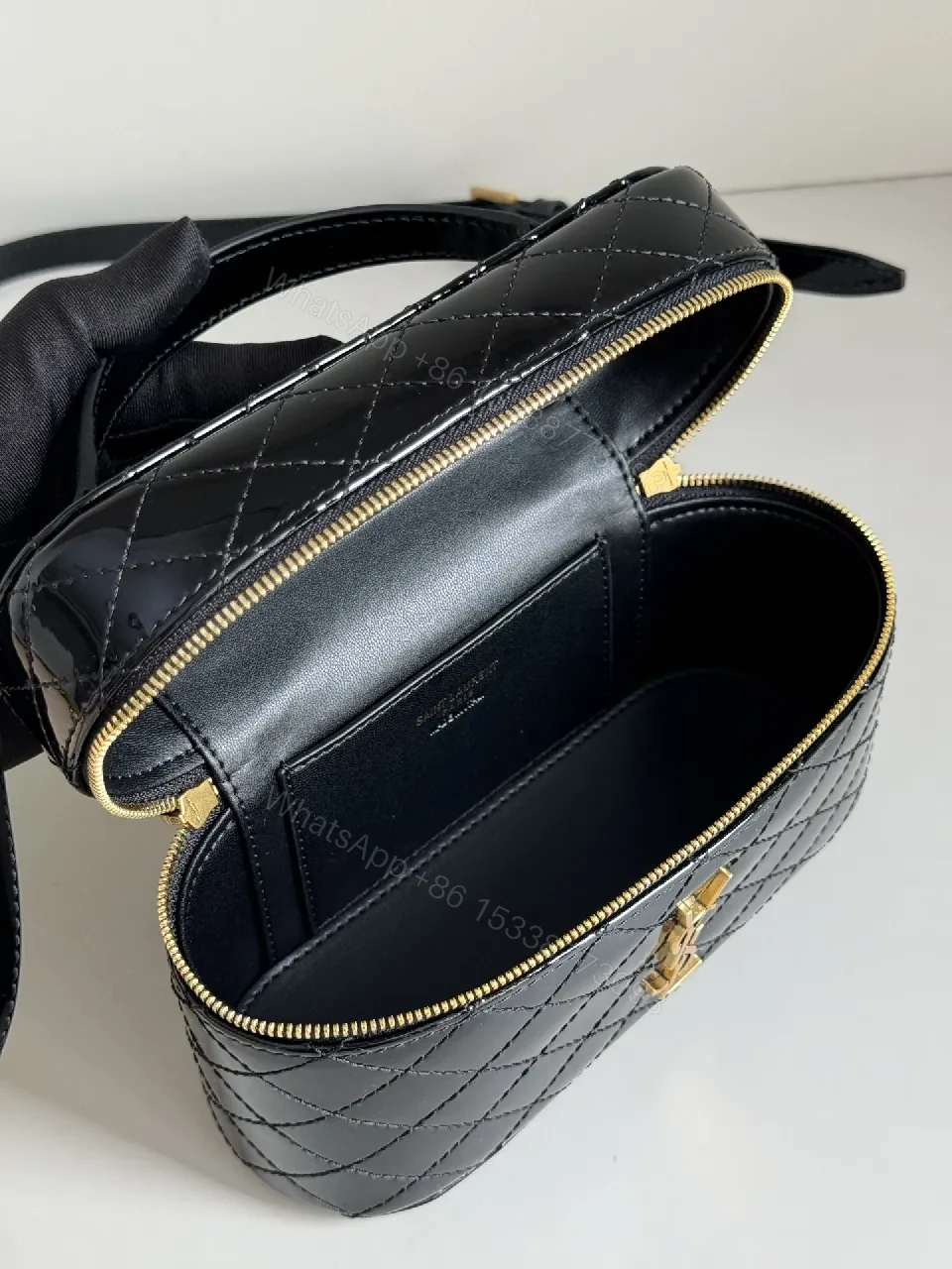 View 9 of Compact Black Quilted Handbag with Gold Accent Emblem
