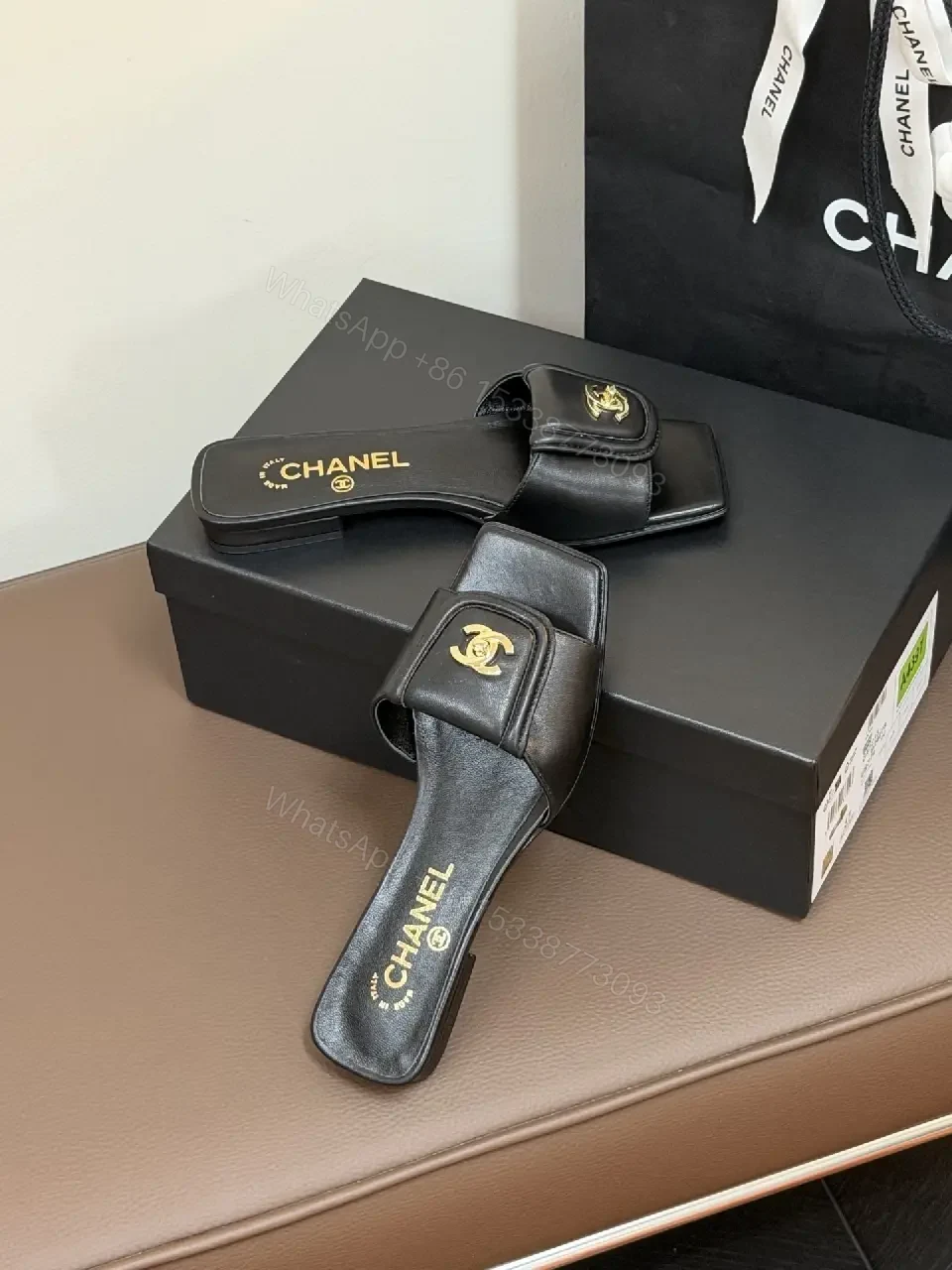 View 4 of Black Leather Mules with Gold Logo Detail – Effortless Chic