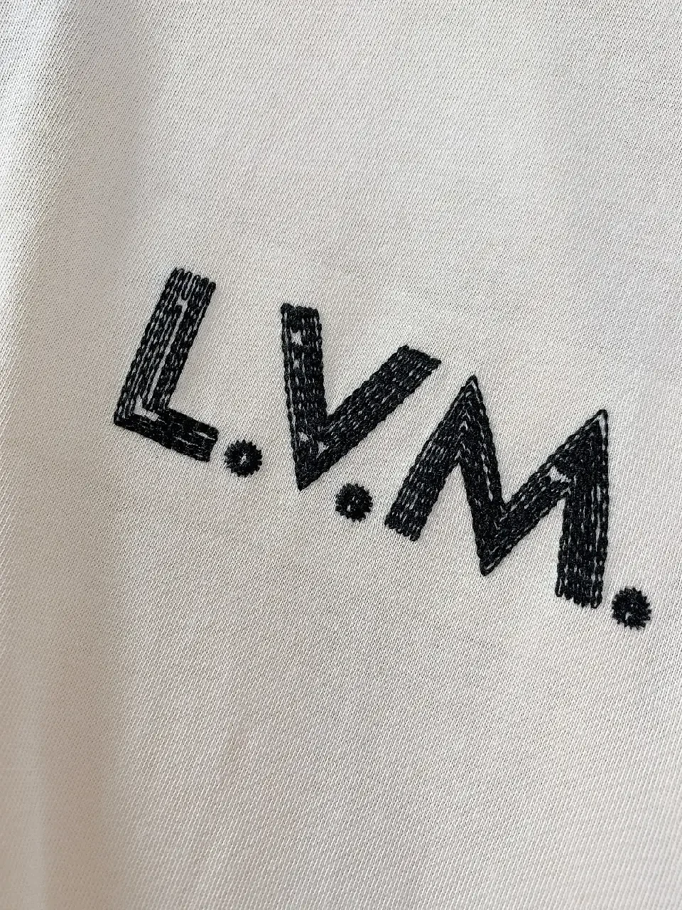 View 8 of Minimalist Off-White Cotton Tee with Signature L.V.M. Accent