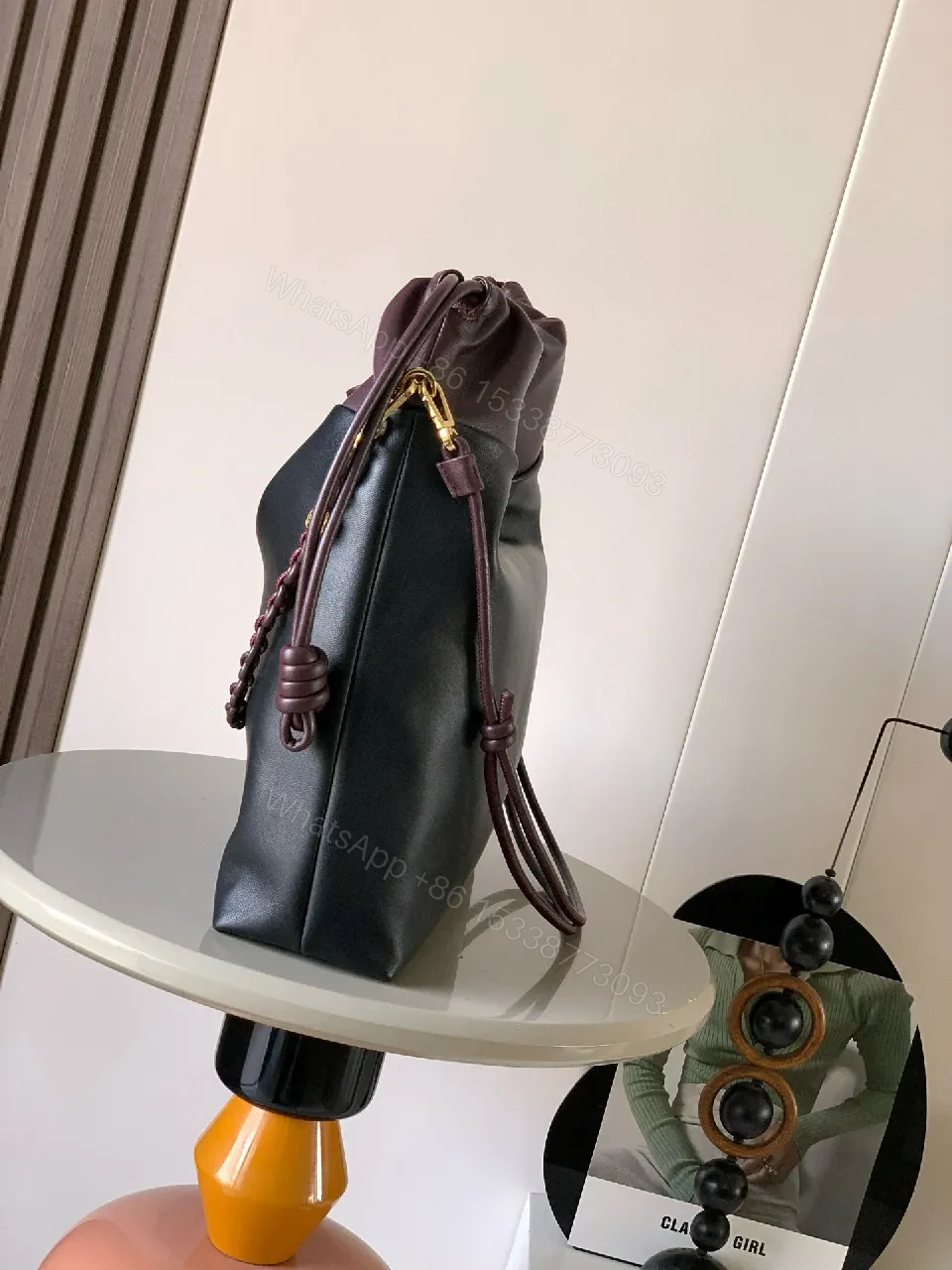 View 2 of Two-Tone Leather Drawstring Bucket Bag with Chain Detail