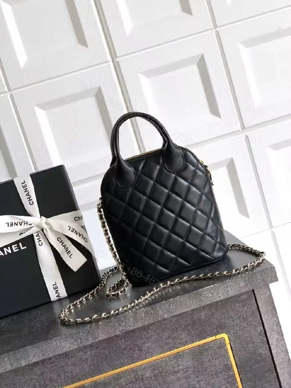 View 3 of Mini Quilted Black Bag with Gold Logo—Refined Daily Companion