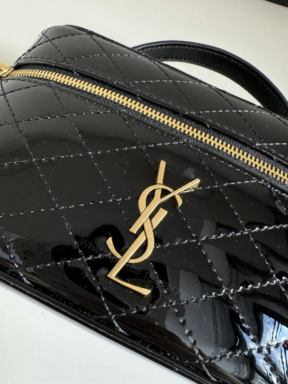 View 8 of Compact Black Quilted Handbag with Gold Accent Emblem