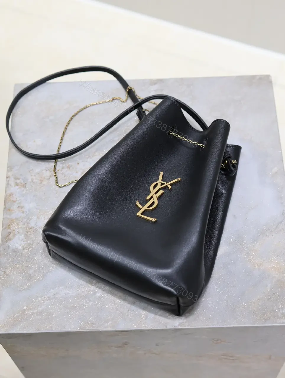 View 10 of Black leather bucket bag with gold-tone YSL monogram and chain straps for everyday luxury