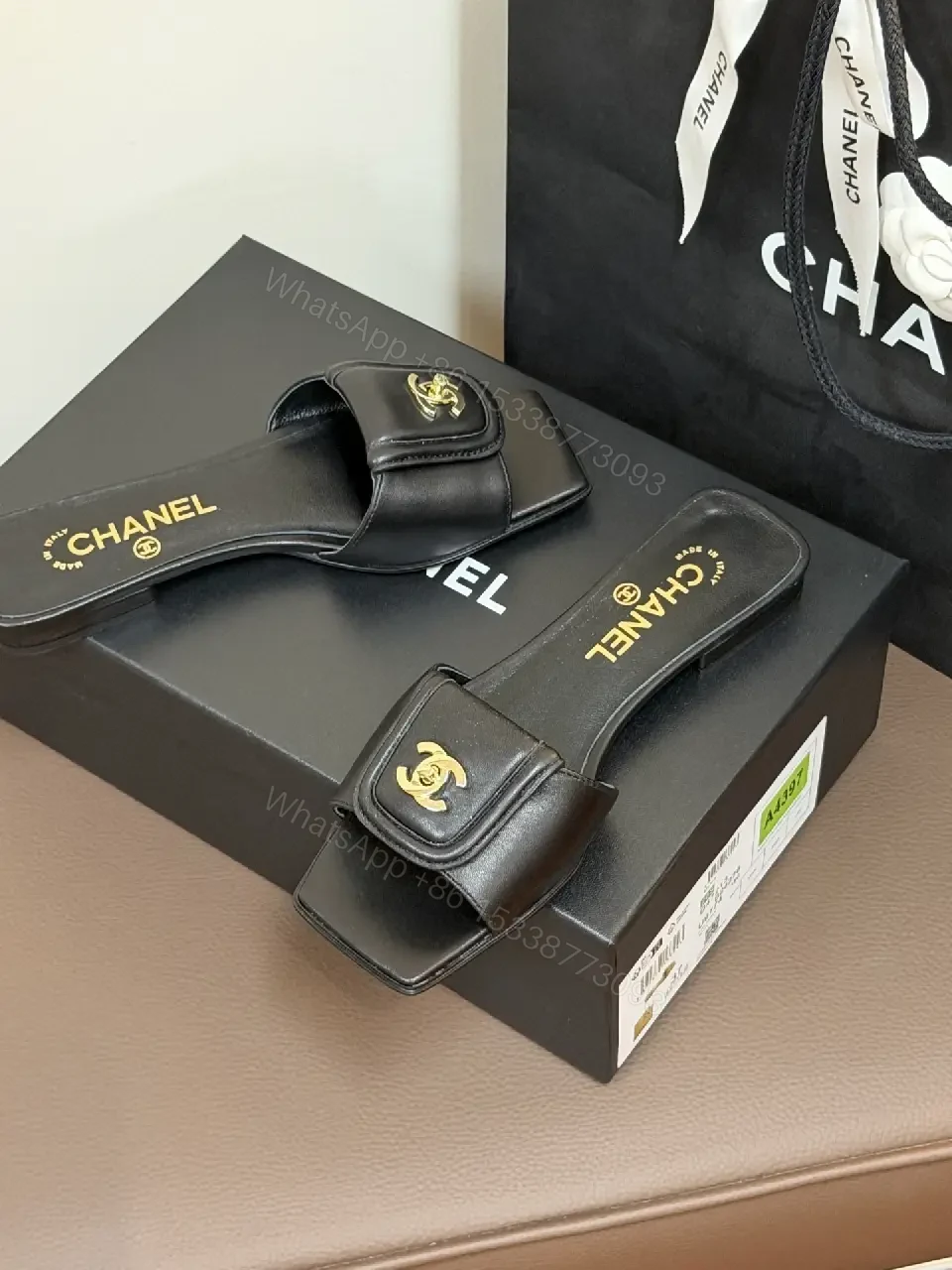View 5 of Black Leather Mules with Gold Logo Detail – Effortless Chic
