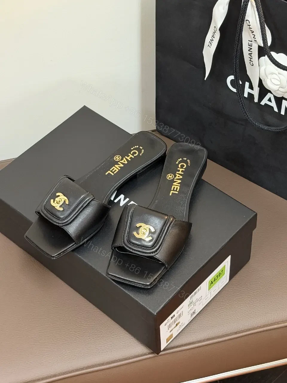 View 3 of Black Leather Mules with Gold Logo Detail – Effortless Chic